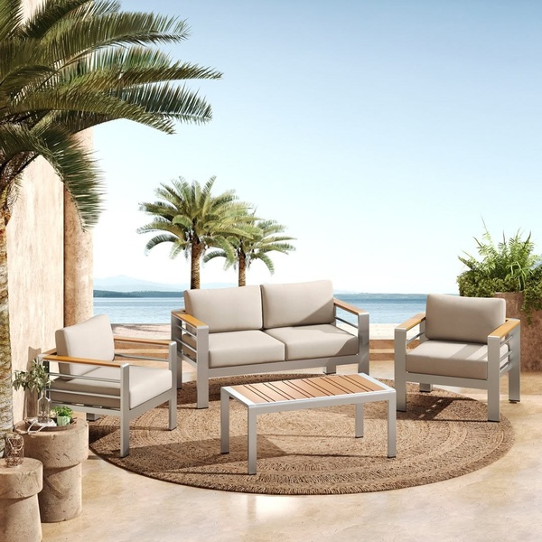 A high-quality 1:1 image showcasing a sleek outdoor furniture set on a tropical patio overlooking the ocean.
