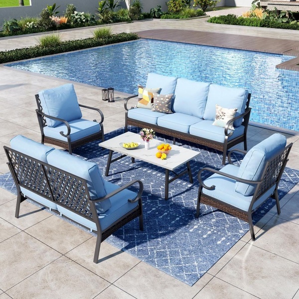 This creative features a high-end outdoor furniture set arranged on a patio by a pool, focusing on clean lines and aspirational, sunny aesthetics.