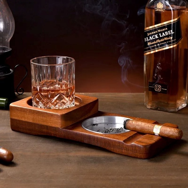 A high-end lifestyle shot featuring a wooden cigar ashtray with a glass of whiskey, designed to evoke a sense of relaxation and sophistication.