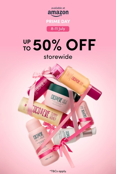 A high-conversion seasonal sale ad featuring a collection of hair care bottles wrapped in a gift ribbon against a soft pink background.