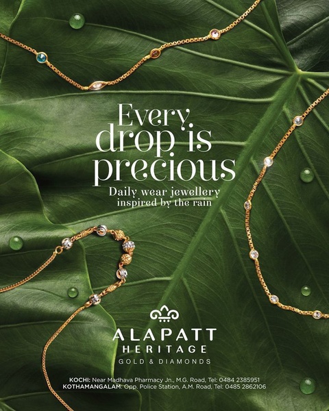 A high-end jewelry advertisement featuring gold and diamond chains draped over a vibrant, dew-covered tropical leaf.