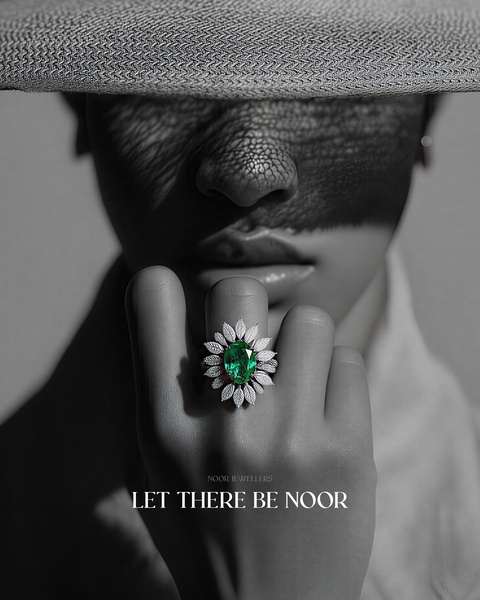 A high-contrast, moody close-up featuring a model wearing a prominent emerald and diamond flower ring, using shadow and mystery as a primary hook.