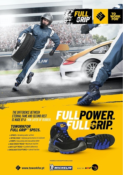 A high-impact ad featuring a worker in racing gear carrying a boot as if it were a tire, highlighting technical grip and durability specs.