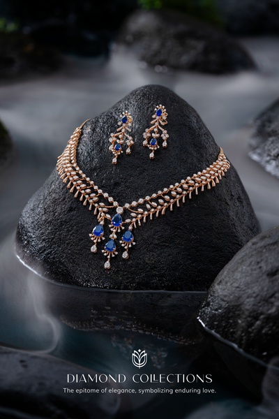 A luxury necklace and earring set is displayed against a natural dark stone in a tranquil water setting to emphasize elegance.