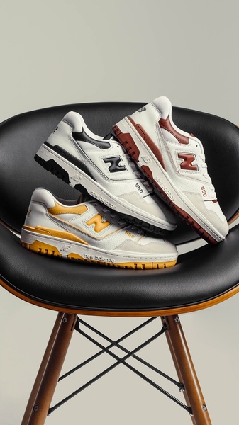 This creative showcases three color variations of the same model running shoe stacked artistically on a designer chair, focusing entirely on product design.