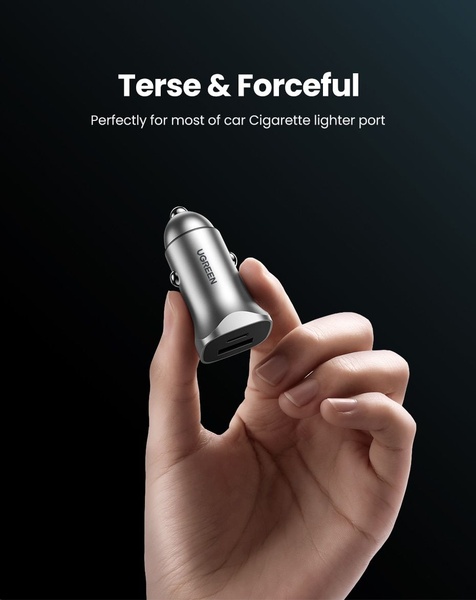 A close-up, high-contrast shot of a sleek car charger held in a hand against a dark, minimalist background.
