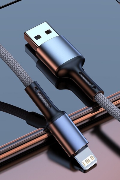 A high-end, studio-lit close-up of a braided charging cable against a reflective surface, emphasizing design quality and texture.