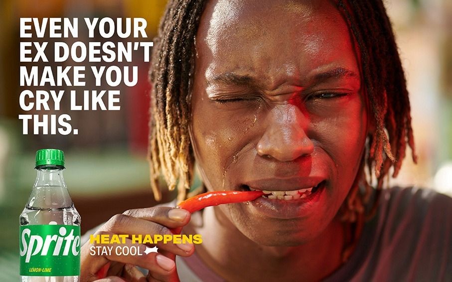 This ad creative features a person eating a red chili pepper, looking pained and teary-eyed, effectively linking the sensation of intense heat to the refreshing relief of a soda.