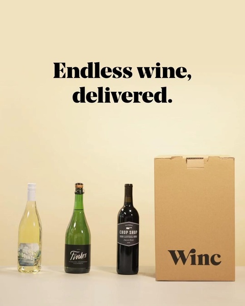 A minimalist studio shot showcasing a wine subscription box alongside three distinct bottles of wine on a clean, light-colored background.