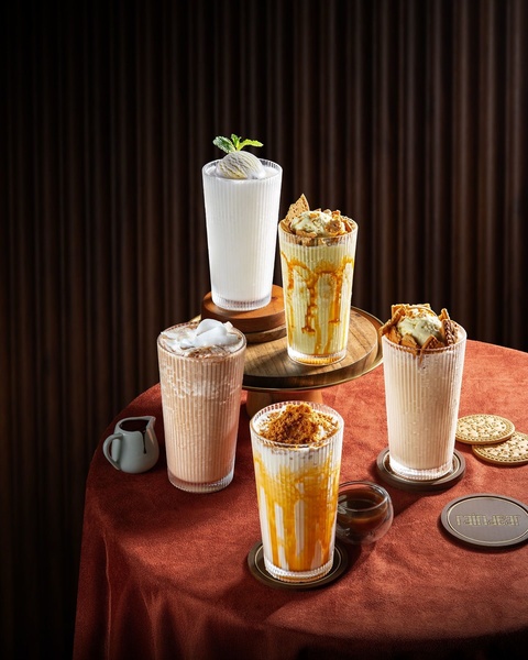 A luxury collection of four iced beverages displayed on a dark, moody tabletop setting to emphasize premium quality.