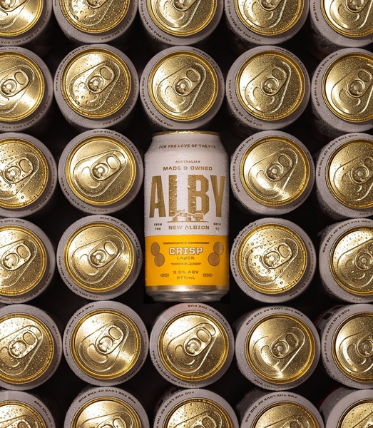 A high-contrast, symmetrical layout featuring a single Alby lager can centered among an identical grid of cans, all glistening with condensation.