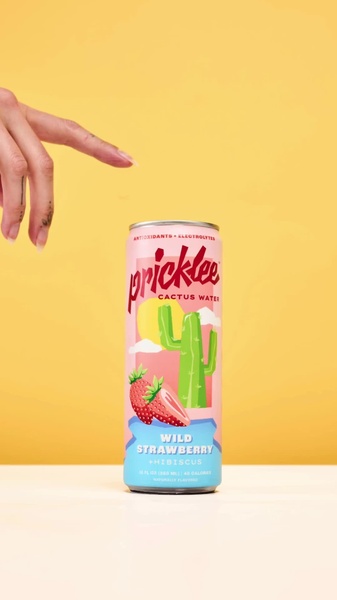 A high-contrast, minimalist shot of a cactus water can being pointed to by a hand, emphasizing product color and clean branding.