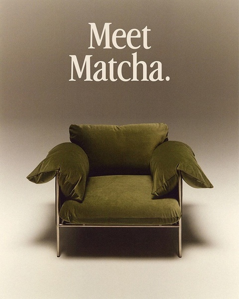 A single-subject studio shot of a velvet armchair against a muted, tone-on-tone background with minimal typography.