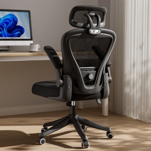 A high-quality, studio-lit photo of an ergonomic office chair featuring a mesh back and adjustable headrest, positioned in a modern home office.