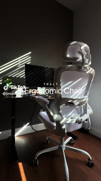 A high-quality, static image of a modern ergonomic chair in a sunlit home office setting designed to highlight product design and comfort.