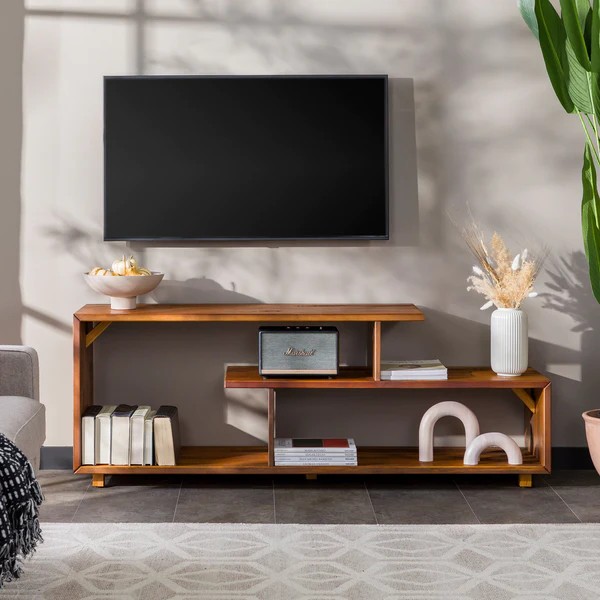 A high-quality, balanced studio shot of a wood media console styled with minimalist decor in a modern, warm living room setting.