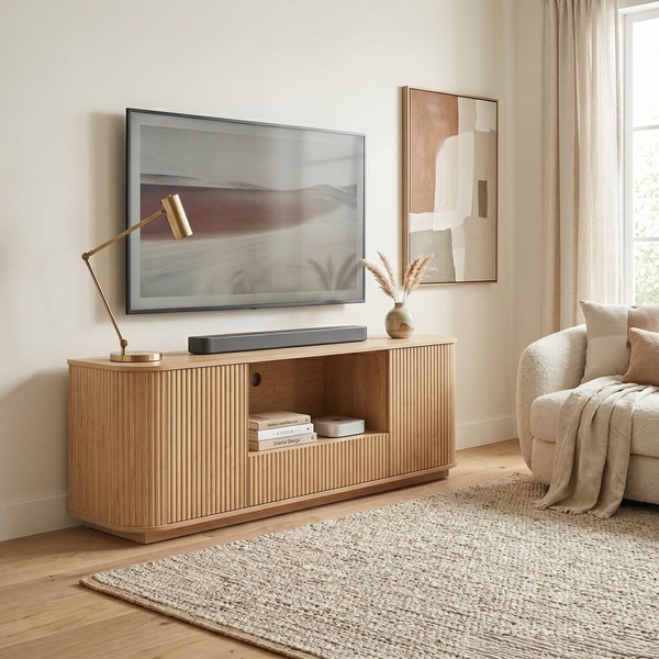 A high-quality, aspirational interior shot featuring a modern ribbed wood media console in a warm, sunlit living space.