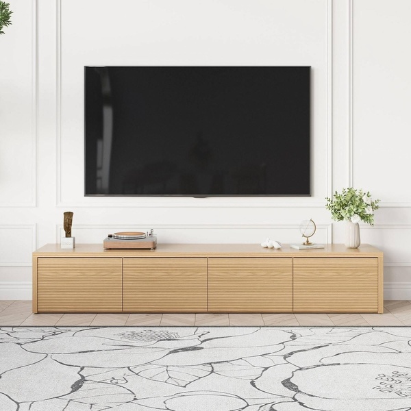 A high-end, clean-focused product photograph featuring a light wood media console beneath a wall-mounted television in a bright, modern living space.