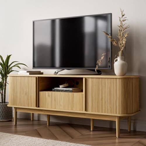 A clean, studio-lit photograph of a slatted wood media console featuring neutral tones and a minimalist aesthetic for high-end home decor.