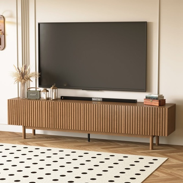 A high-end media console featuring slatted wooden doors, staged in a bright, modern living space to emphasize premium aesthetic.