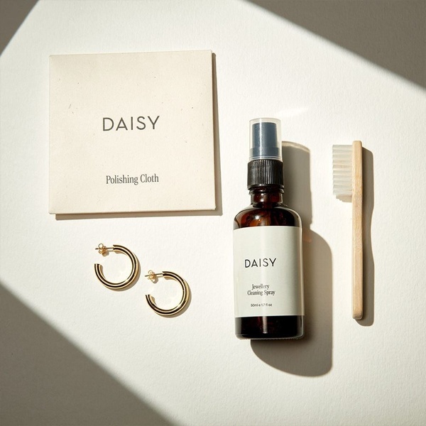 jewelry cleaner, cleaning spray, polishing cloth, cleaning brush, jewelry care kit, product demo, minimalist, flat lay, calm, trustworthy, neutral