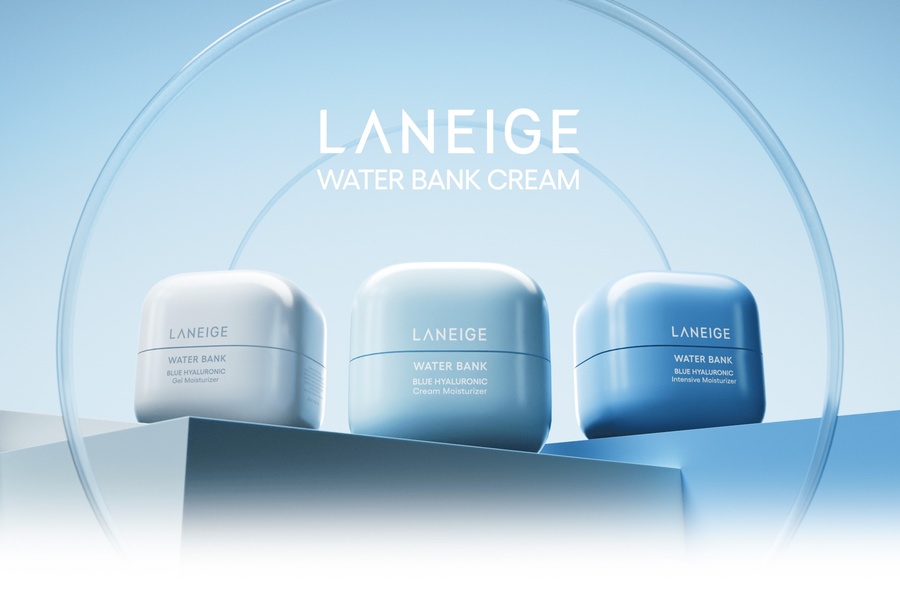 A clean, high-end product photography shot featuring three jars of moisturizer cream arranged on geometric platforms under a soft, blue-toned light.