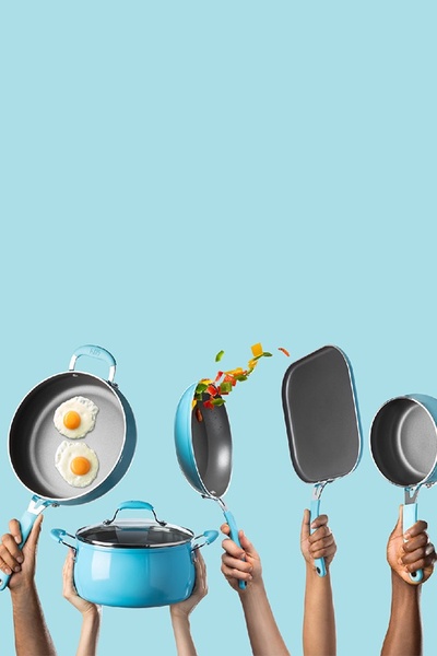 A high-energy, minimalist composition featuring various pieces of light blue cookware held up by multiple hands against a solid color background.