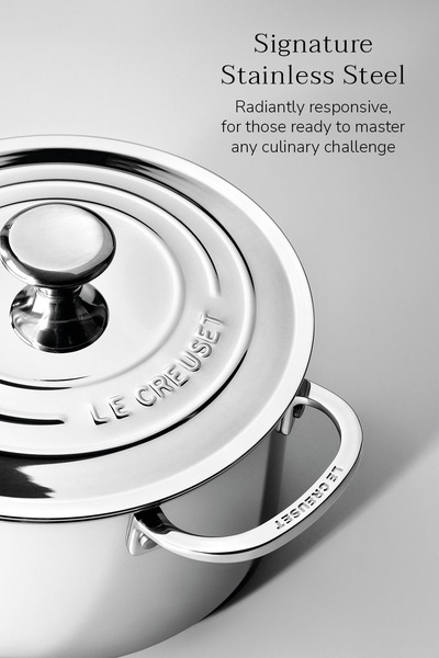 A close-up studio shot of a high-end stainless steel pot set against a soft gray backdrop, emphasizing premium quality through simplicity.