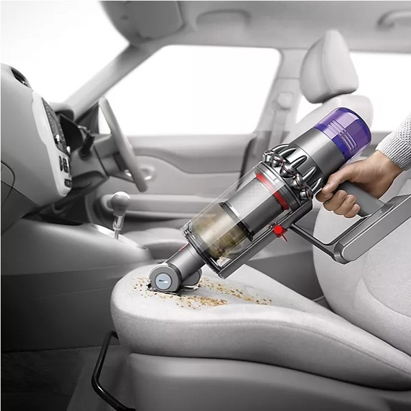 This creative showcases the powerful suction capabilities of a handheld vacuum while cleaning debris off a car seat.