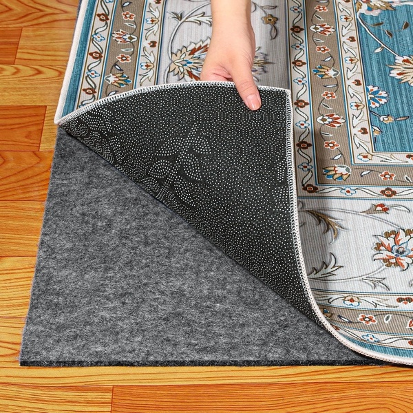 A close-up demonstration showing the non-slip backing of an area rug being lifted from its floor-grip pad.