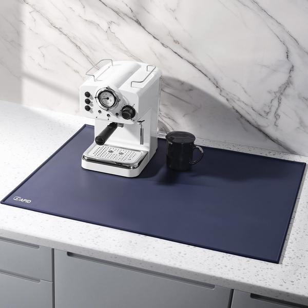 A high-quality, top-down lifestyle shot featuring a coffee mat under a premium espresso machine on a marble countertop.