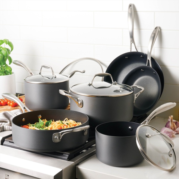 A high-quality product photography shot of a complete matte-finish cookware set arranged on a stove, featuring neutral tones and professional lighting.