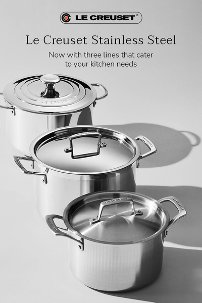 A high-quality studio shot of three stacked stainless steel pots against a neutral grey background to emphasize product design.