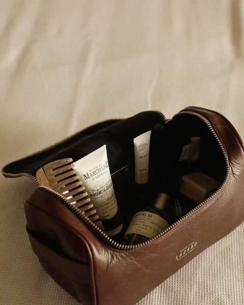 toiletry bag, leather travel kit, dopp kit, cosmetic pouch, travel bag, product demo, lifestyle, calm, luxurious, brown, neutral