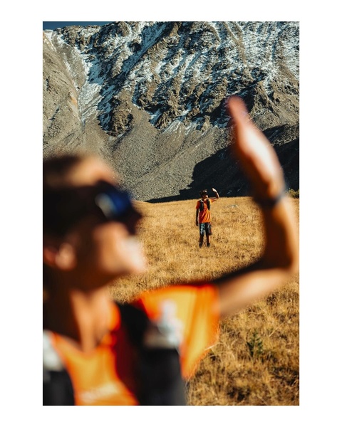A creative showing a runner in the distance captured through the blurred, out-of-focus hand and forearm of the photographer to create a sense of scale.