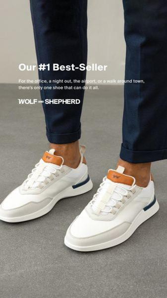A close-up, high-angle product shot of white sneakers on a person wearing navy trousers, utilizing a clear value proposition as the central hook.