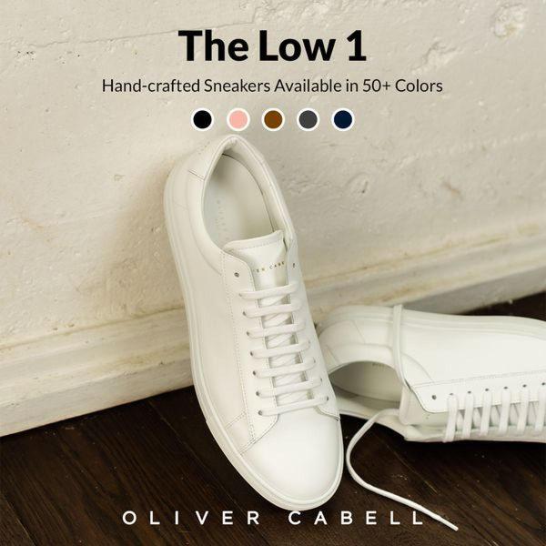 A clean, studio-lit photograph of a premium leather sneaker resting against a textured wall, highlighting color variety and craftsmanship.