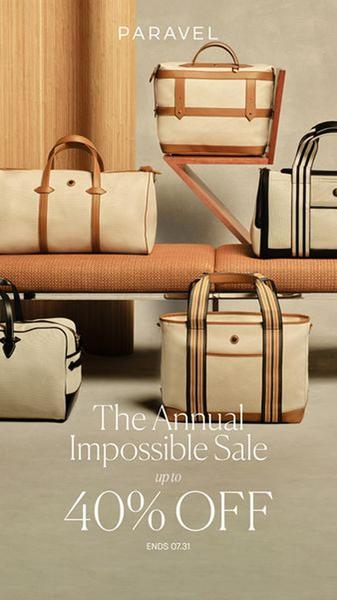 A high-end lifestyle shot featuring multiple travel bags arranged on modern furniture, utilizing neutral tones to communicate premium quality and seasonal pricing.