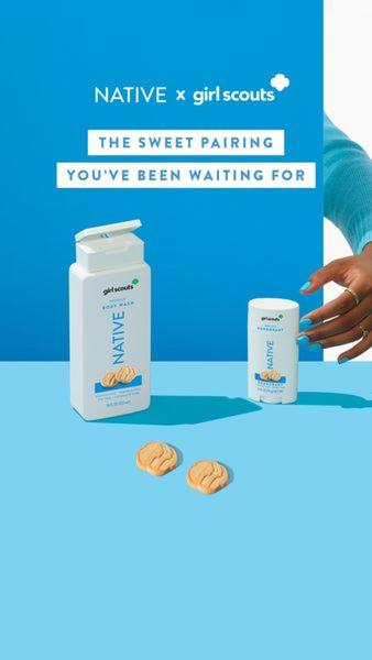 A high-contrast vertical ad showing a body wash bottle and deodorant stick alongside Girl Scout cookies, held by a hand with matching blue nail polish.