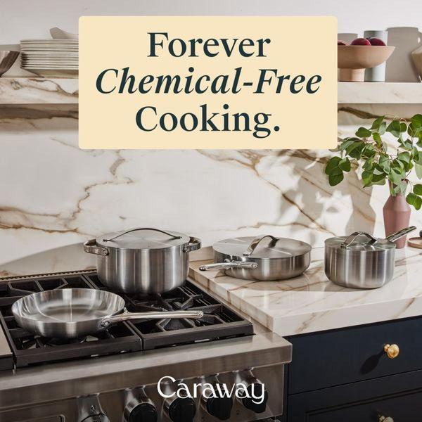 A high-end, clean product shot of a stainless steel cookware set sitting on a professional-grade kitchen stove.
