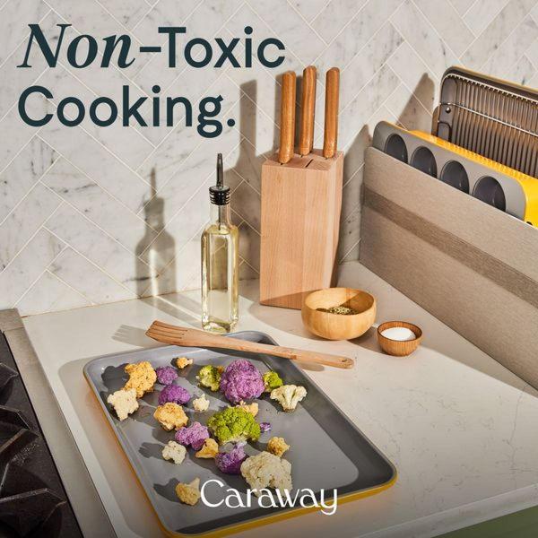 A high-contrast, clean studio shot of a ceramic baking sheet with fresh, colorful cauliflower on a marble surface.