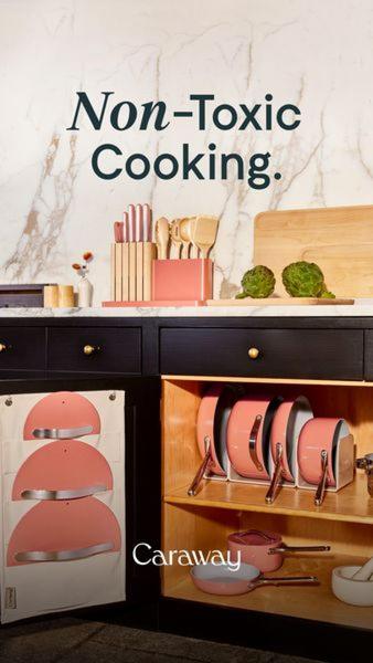 A high-contrast, clean interior shot showcasing a color-coordinated kitchen drawer filled with pink cookware and matching knives.
