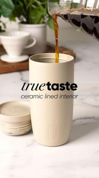 A high-quality 9:16 vertical image showing a fresh pour of coffee into a minimalist beige ceramic lined travel mug.