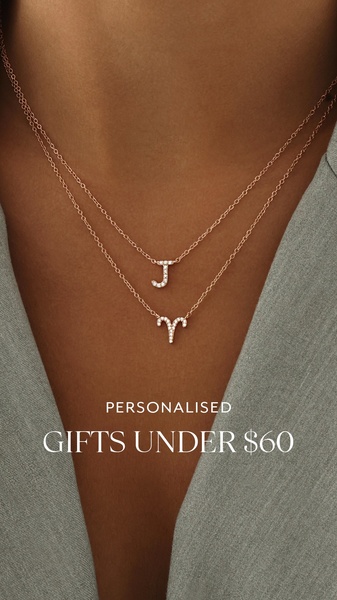 A close-up, elegant shot of two layered necklaces featuring initials, highlighting a price-based promotion for personalized gift items.