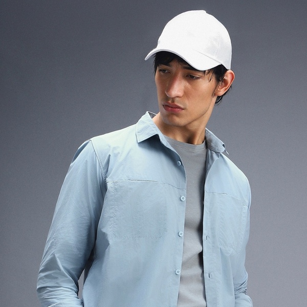 A high-quality, studio-lit product image featuring a model wearing a plain white baseball cap, emphasizing a clean and professional lifestyle aesthetic.