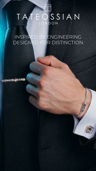 A high-end, close-up shot of a man in a formal suit displaying a tie bar and matching cufflink to emphasize engineering precision.