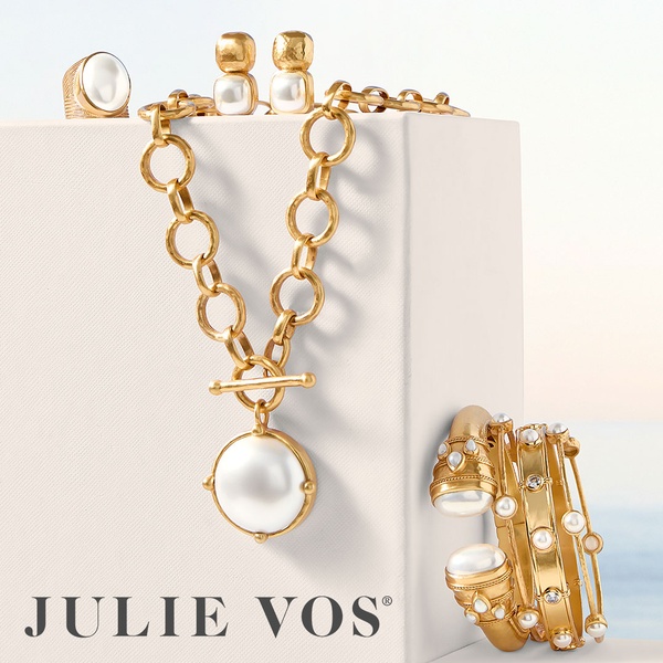 A high-end, clean-composition hero shot showcasing a set of gold and pearl necklaces, rings, and earrings on a white display block.