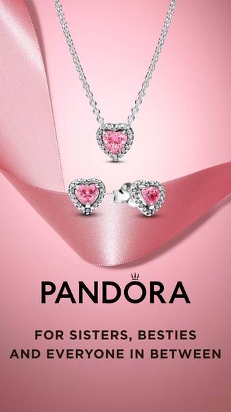 A high-conversion 9:16 vertical creative featuring a heart-shaped necklace and earring set on a soft pink background to evoke a giftable, celebratory mood.