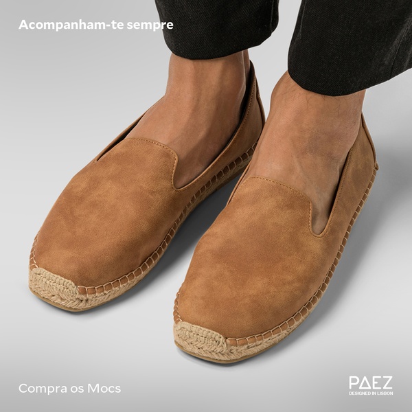 A close-up, high-quality product shot of brown suede espadrilles on feet against a neutral background, focusing on comfort and brand identity.