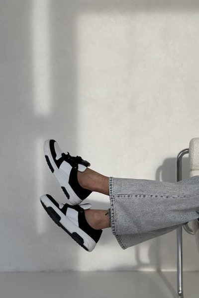 This ad creative features a close-up lifestyle shot of casual black and white sneakers, emphasizing a clean, neutral-toned aesthetic.